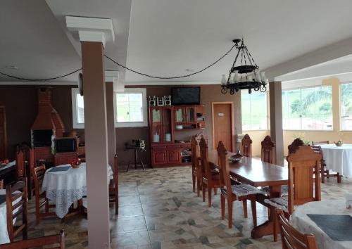 a dining room and kitchen with a table and chairs at Hotel Avenida in Pardinho