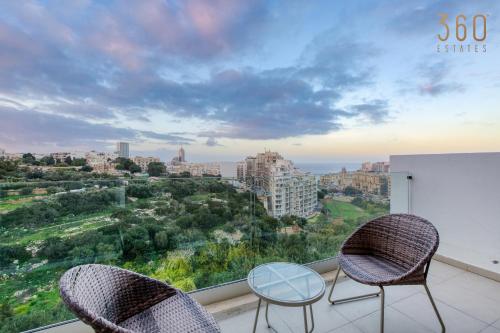 - Balcón con 2 sillas y mesa de cristal en A fully equipped 3BR home with lovely views & WIFI, en San Julián