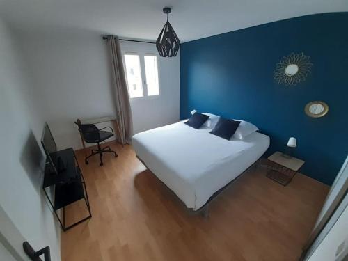 - une chambre avec un lit blanc et un mur bleu dans l'établissement TY ARVOR Maison à 5 minutes de la plage Concarneau, à Concarneau