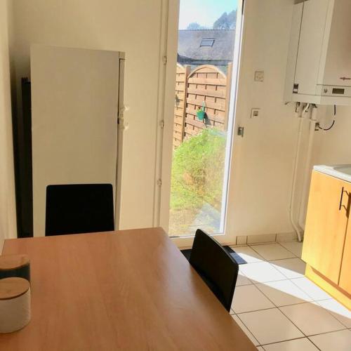 une cuisine avec une table et des chaises et une fenêtre dans l'établissement TY ARVOR Maison à 5 minutes de la plage Concarneau, à Concarneau