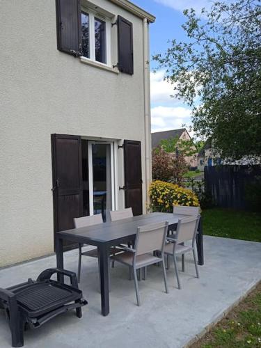 une table et des chaises noires, un grill ainsi qu'une table et des chaises dans l'établissement TY ARVOR Maison à 5 minutes de la plage Concarneau, à Concarneau