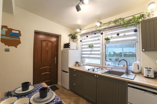 a kitchen with a sink and a refrigerator and a window at Apartament Żeromskiego 1 in Sandomierz