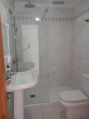 uma casa de banho com um chuveiro, um lavatório e um WC. em ATICO AL LADO DEL MAR em Barreiros