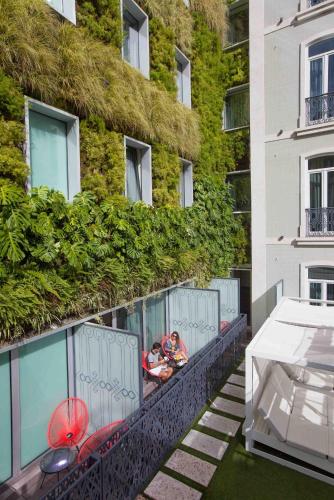 a balcony of a building with people in a pool at BessaHotel Liberdade in Lisbon