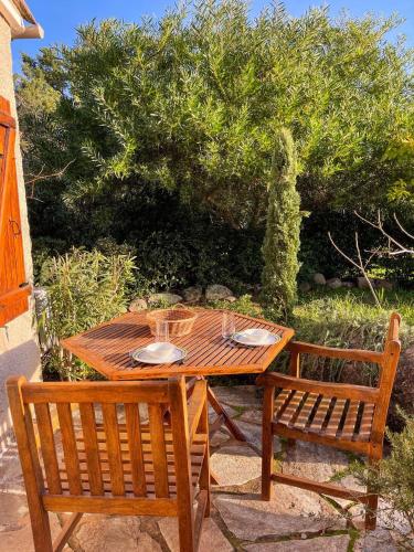 une table en bois et deux chaises assises à côté d'une table dans l'établissement Villa Argentella, Santa Giulia, à Porto-Vecchio