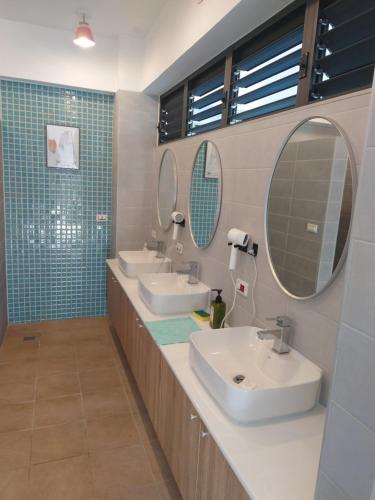 a bathroom with two sinks and two mirrors at Oceans Explore Hostel in Green Island