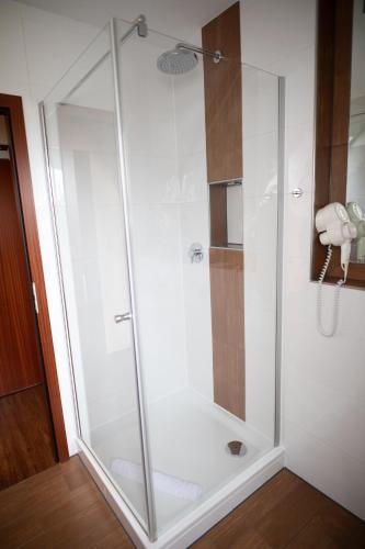 a shower with a glass door in a bathroom at Vier Jahreszeiten Rooms in Husum