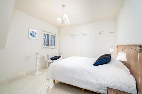 ein Schlafzimmer mit einem Bett mit einem blauen Kissen darauf in der Unterkunft CAPRINO Guesthouse in Knokke-Heist