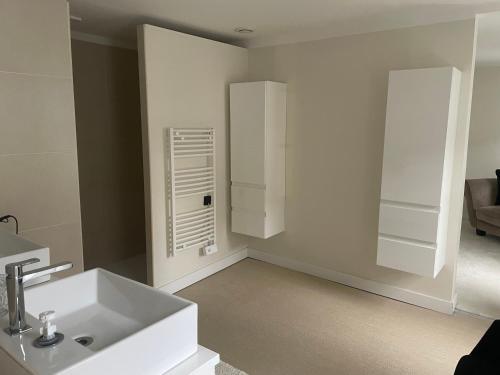 a bathroom with a white sink in a room at Les Suites de la Comtesse in Cambrai