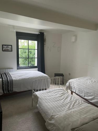 um quarto com 2 camas e uma janela em Les Suites de la Comtesse em Cambrai