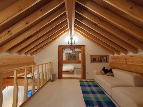 ein Wohnzimmer mit Holzdecken und einem Sofa in der Unterkunft Haenggung stay Dalno - Suwon private house hanok in Suwon