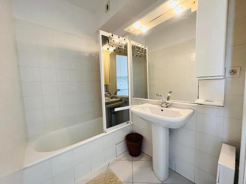 une salle de bain avec un lavabo, un miroir et une baignoire dans l'établissement Appartement 19 Les Carolines 2 Calvi, à Calvi
