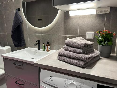 y baño con lavabo, espejo y toallas. en Hagastaden flat, en Estocolmo