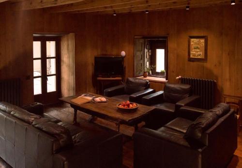 sala de estar con sofás de cuero y mesa de centro en Casa rural Casa Bernat en Isil