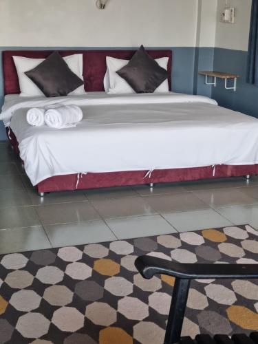 a large bed in a room with a rug at Sams ChiangKhan in Chiang Khan