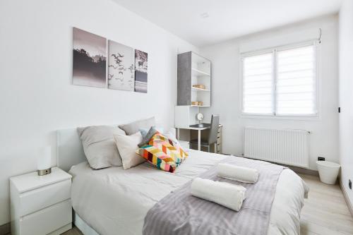 Un dormitorio blanco con una cama grande y una ventana en Appartement Loft Cosy - 15mn de Paris ! All Inclusive, en Fontenay-aux-Roses