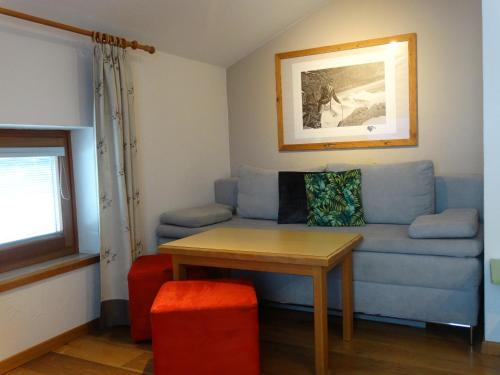 a living room with a blue couch and a table at Landhaus Alpengruss in Kössen