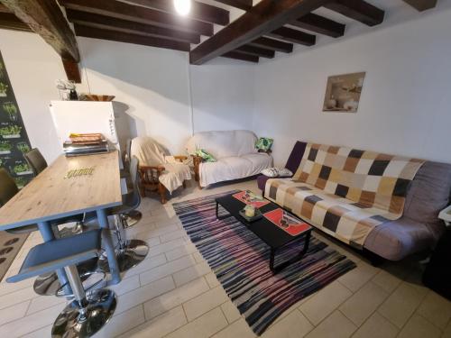 un salon avec un canapé et une table dans l'établissement La tourelle de la chaumière, à Goupillières