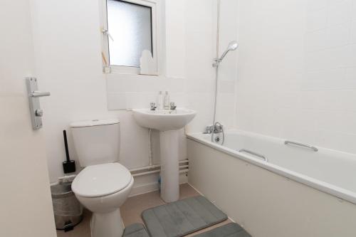 a white bathroom with a toilet and a sink at Modern 1 bed flat on the outskirts of Kingston in Teddington