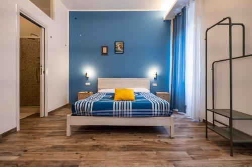 ローマにあるLocazione Turistica Civico 60の青い壁のベッドルーム1室、ベッド1台(黄色い枕付)
