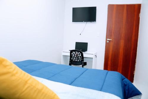 a bedroom with a bed and a desk with a computer at POUSADA FLAT MÃE RAINHA in Maceió