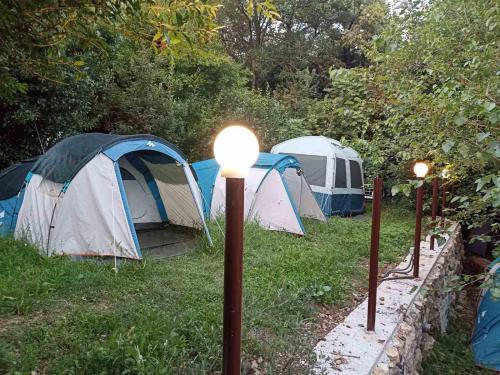 drei Zelte auf einem Feld mit Lichtern im Gras in der Unterkunft Kamp Seosko domaćinstvo Radman - Šator arpenaz 4 in Herceg-Novi