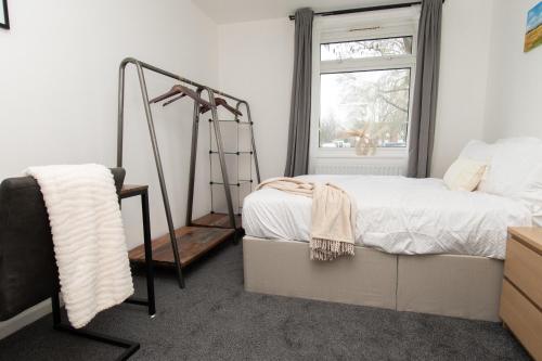 a bedroom with a bed and a ladder next to a window at Modern 1 bed flat on the outskirts of Kingston in Teddington