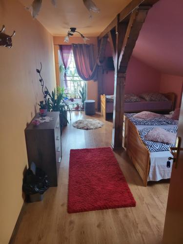 ルバフカにあるAgroturystyka Świerkiのベッド2台と赤い敷物が備わる客室です。