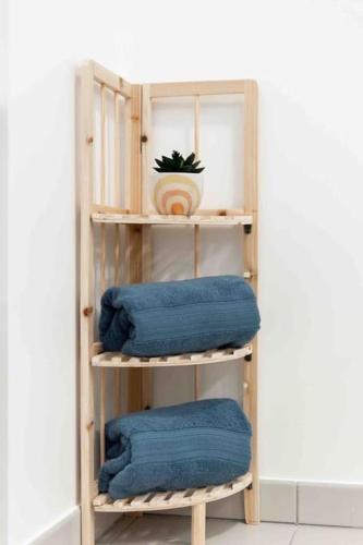 - une étagère en bois avec 3 serviettes bleues dans l'établissement Appartement moderne, Metro 7, Parking et Jardin, à Villejuif