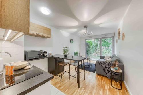 Una cocina y una sala de estar con una mesa y un sofá. en Appartement moderne, Metro 7, Parking et Jardin, en Villejuif