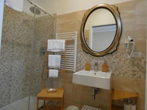 La salle de bains est pourvue d'un lavabo et d'un miroir. dans l'établissement Guest house Il Giardino in Città, à La Spezia