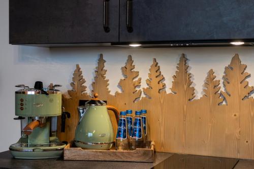 a kitchen counter with a mixer and a wooden wall at Pensjonat Orlik Mountain Resort&SPA in Bukowina Tatrzańska