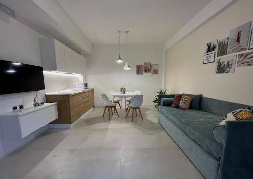 a living room with a green couch and a table at Corte Cesarina in Porto Cesareo