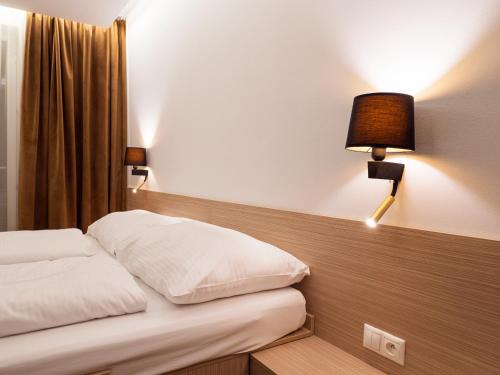 a bed in a hotel room with two lamps on it at ELITE HOTEL Nová Dubnica in Nová Dubnica
