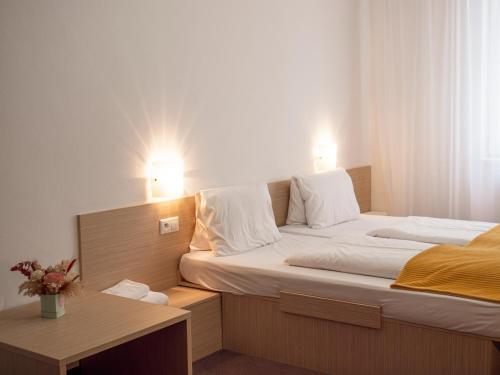 a bedroom with a large bed with two lights on it at ELITE HOTEL Nová Dubnica in Nová Dubnica