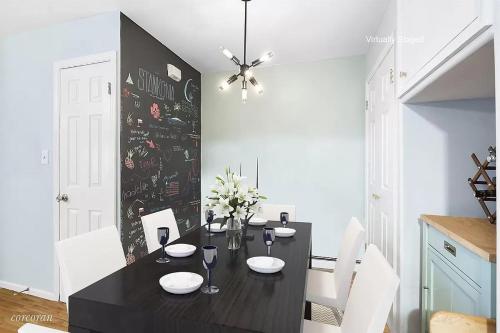 a dining room with a black table and white chairs at Private room in 4 bedroom Ground Apartment near Subway in Brooklyn
