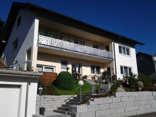 ein weißes Haus mit Balkon darüber in der Unterkunft Ferienwohnung Ehret in Wald-Michelbach