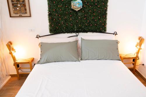a bedroom with a white bed with two chairs at beb Da basso experience Napoli Toledo, Pompeii, Ercolano and Vesuvio in San Giorgio a Cremano