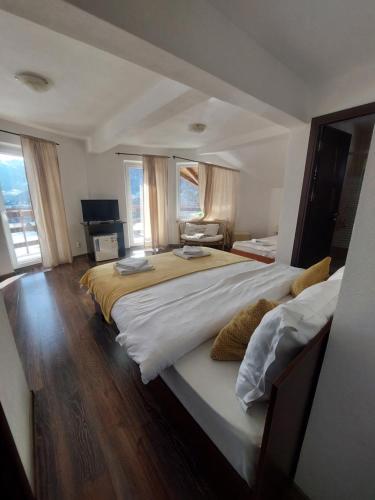 a large bedroom with a large bed with white sheets at Casa Tamara in Bran