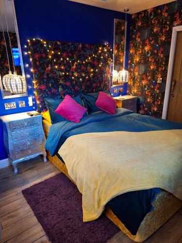 1 dormitorio con 1 cama grande con almohadas rosas en Park House Studio en Matlock
