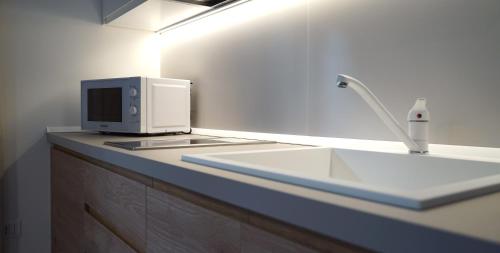 a kitchen counter with a microwave and a sink at Corte Cesarina in Porto Cesareo