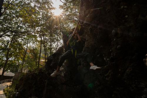 a person is climbing on a rock wall at ONENESS Rishikesh by Ganga Kinare - A Luxury Wilderness Resort in Rishīkesh