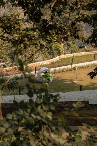 a person sitting in a tire in a park at ONENESS Rishikesh by Ganga Kinare - A Luxury Wilderness Resort in Rishīkesh