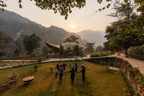 a group of people standing in a circle holding hands at ONENESS Rishikesh by Ganga Kinare - A Luxury Wilderness Resort in Rishīkesh