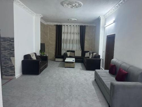 a living room with couches and chairs in a room at شقه للأيجار في الحي الشرقي in Irbid