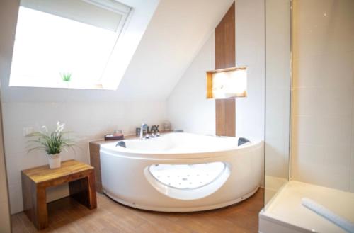 uma banheira na casa de banho com uma janela em Vier Jahreszeiten Suite mit Whirlpool Badewanne L Vazzano em Husum