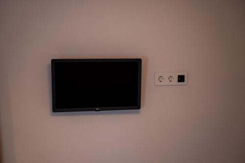 a flat screen tv hanging on a wall at La Siesta Hostel in Almarda