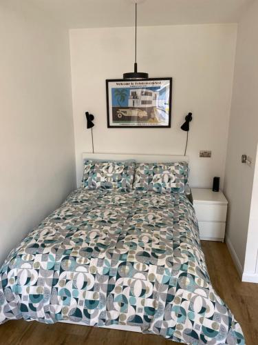 a bedroom with a bed with a comforter at The Studio in Frinton-on-Sea