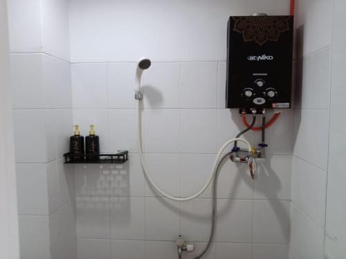 y baño con ducha y cabezal de ducha. en Sansan Room - Apartemen Gunung Putri Square, en Parungdengdek