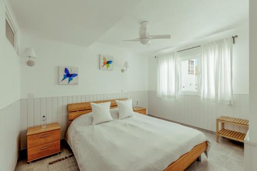 a white bedroom with a large bed and a window at Algés Village Casa 2 by Lisbon-Coast vacation in Algés